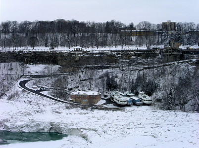 [Maids of Mist boats docked against the river's edge above the ice.]